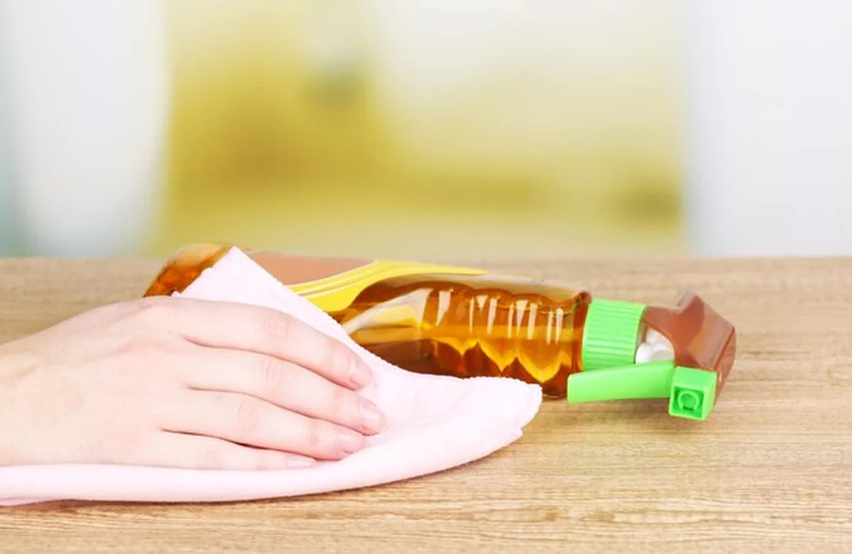 Ręczne czyszczenie drewnianego stołu pastą do mebli