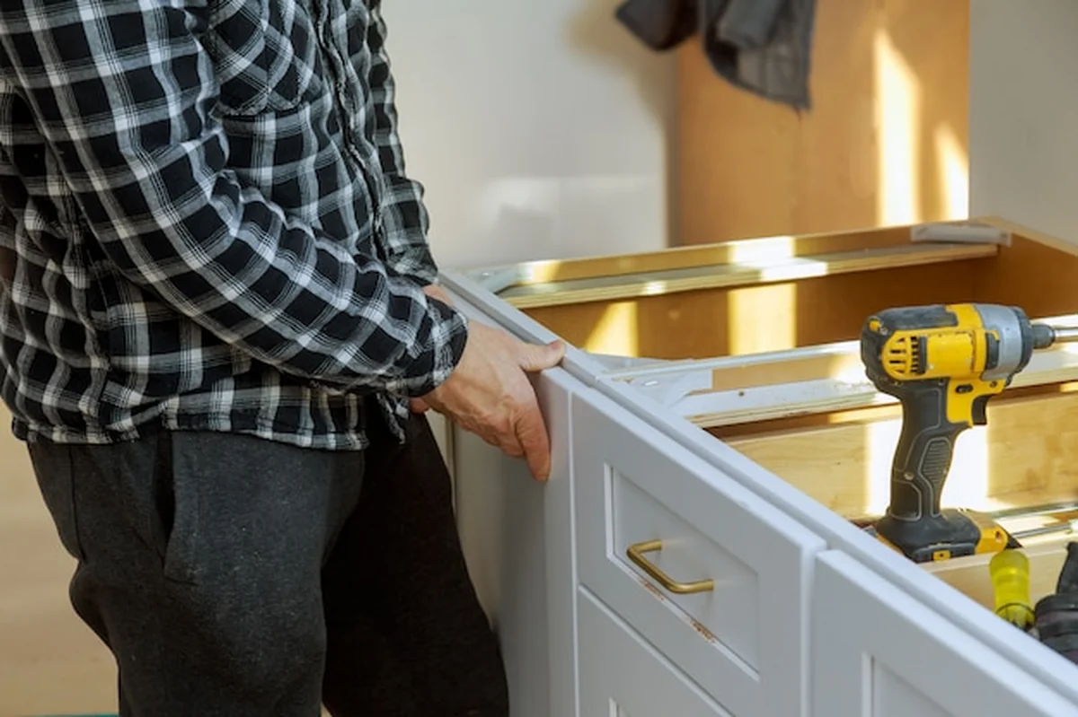 Montaż białych dużych kubełków na śmieci za pomocą śrubokręta