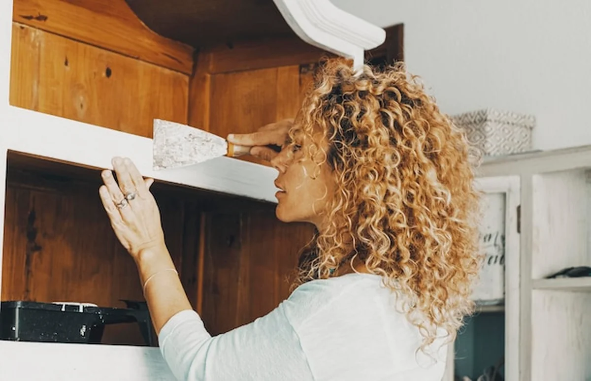 Kobieta odnawia stare meble kuchenne