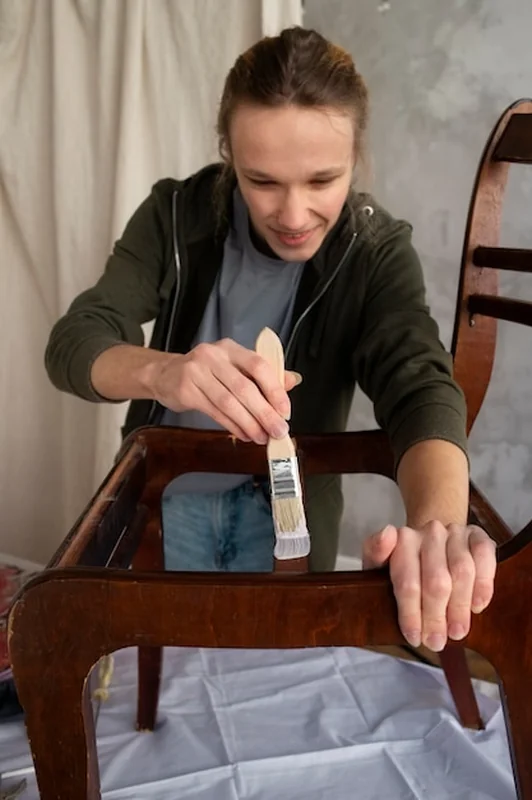 Młody dorosły naprawia stare krzesło