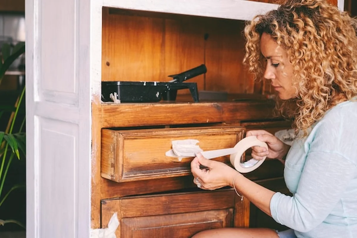 Dorosła kobieta odnawia stare meble kuchenne