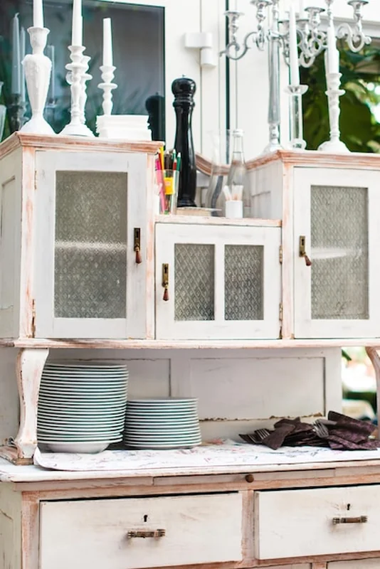 Stara kuchnia w stylu vintage z białą szafką i porcelanową zastawą stołową