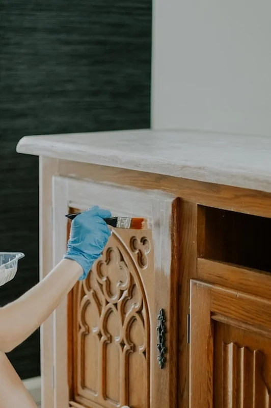 Młoda dziewczyna maluje starą garderobę