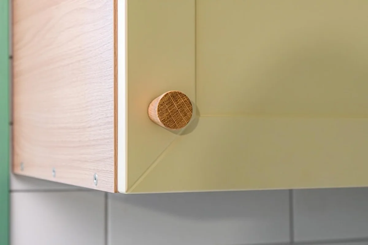 Minimalistyczne drewniane uchwyty na nowoczesnej szafce kuchennej
